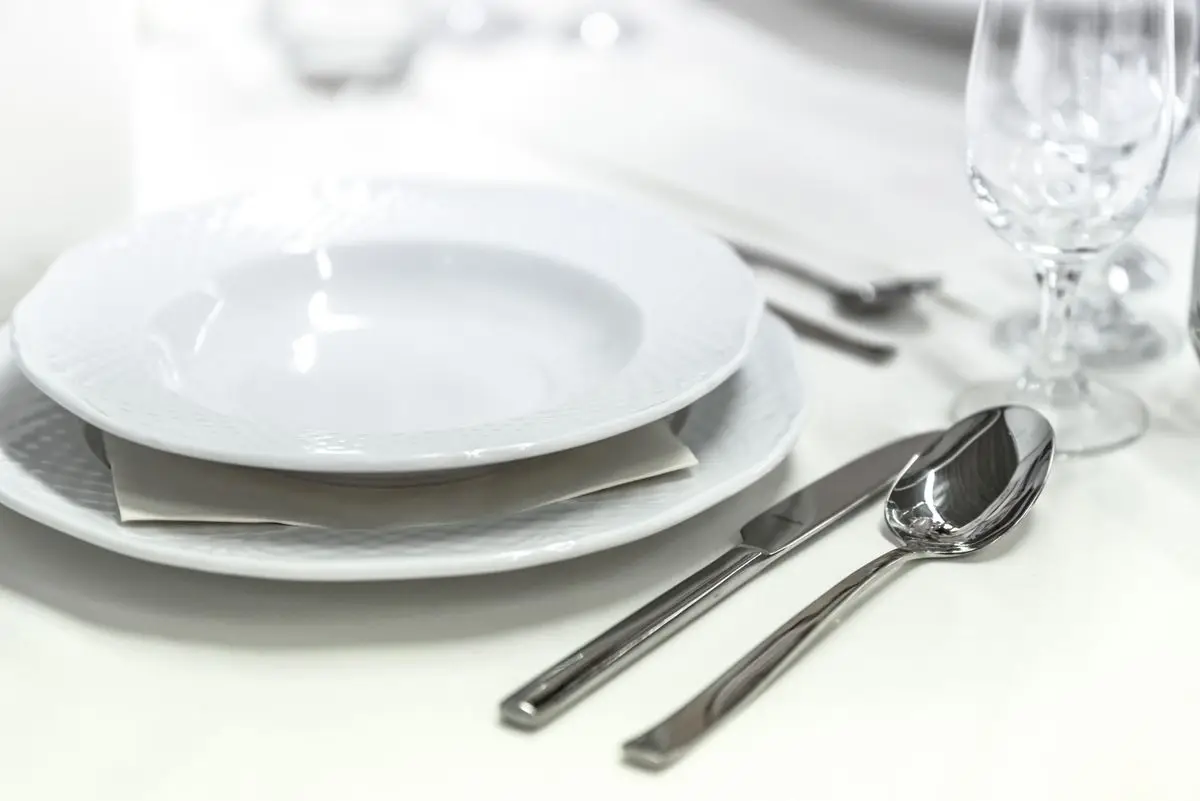 Mesa servida con platos de porcelana y cubiertos